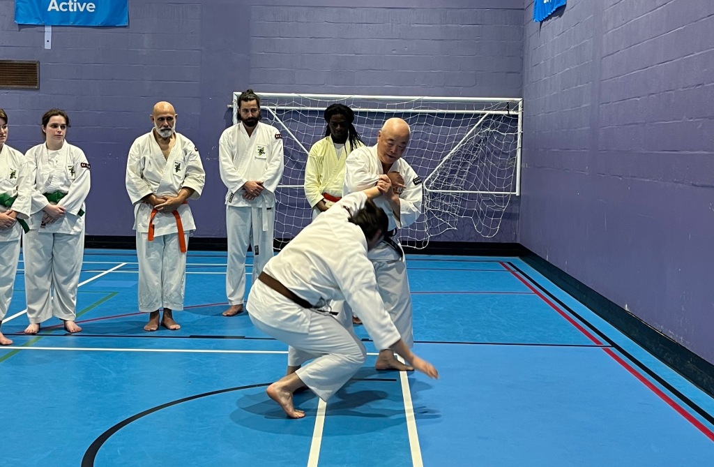 The head of the BSKF demonstrates a throwing technique to a group of students.
